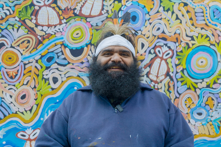 Cedric Varcoe in front of mural