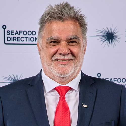 Man wearing black suit white shirt and red tie