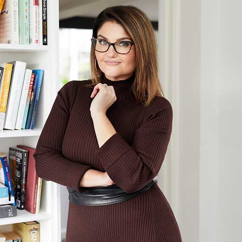 Woman wearing glasses, long-sleeved dress and leather belt