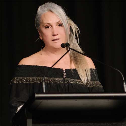 Woman in black dress at lectern