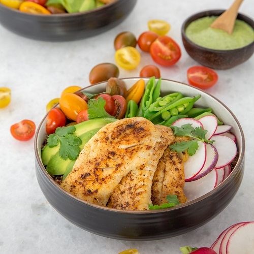 Alaska koolvis regenboog bowl met romige groene dressing