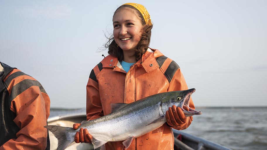 Fischerin hält Lachs in der Hand
