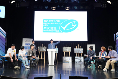 会場のモニターに映し出されたMSC「海のエコラベル」を説明するココリコ田中さん