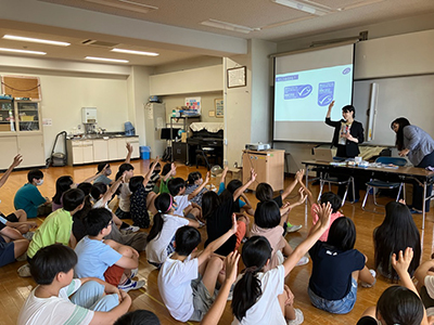 目黒区立五本木小学校でのMSCジャパンの特別授業の様子。スクリーンにMSC「海のエコラベル」が映し出され、子どもたちが手を挙げている。