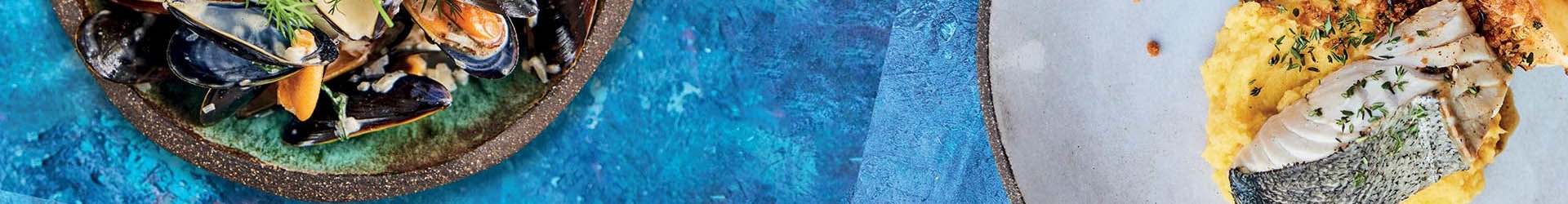 Plates of seafood on blue background