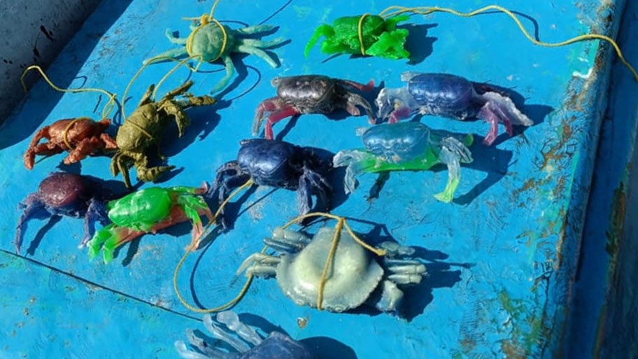 Colourful PVC fake crab lures lined up on boat deck
