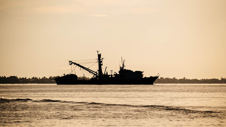 Silhouette of large fishing vessel on water