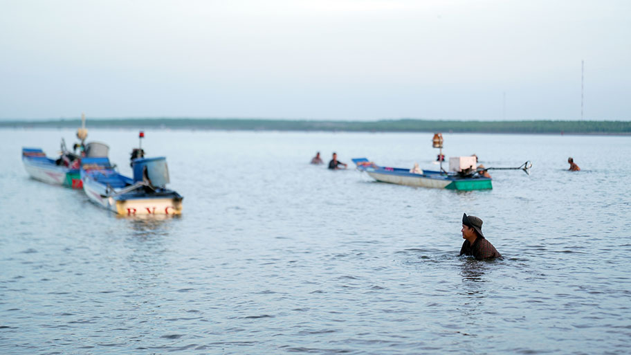 Clam fishers in water and in small boats, Ben Tre, Vietnam