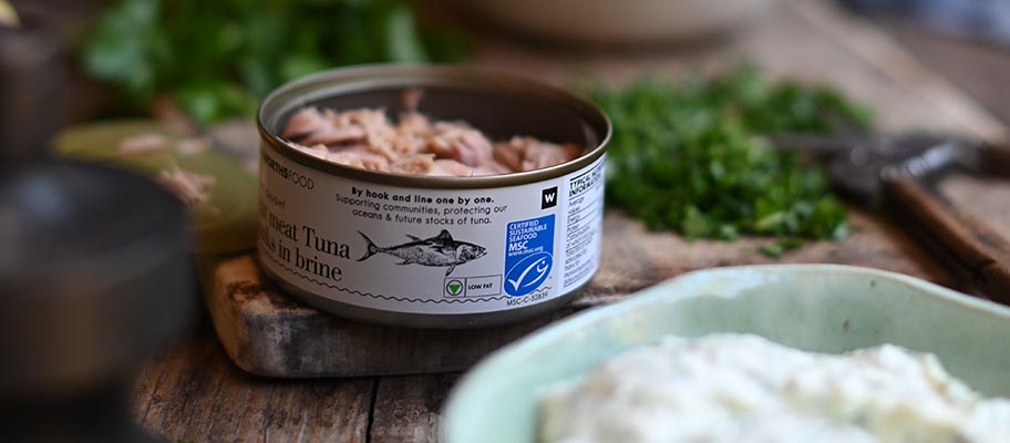 Can of tuna with MSC label on board with bowl of mayonnaise