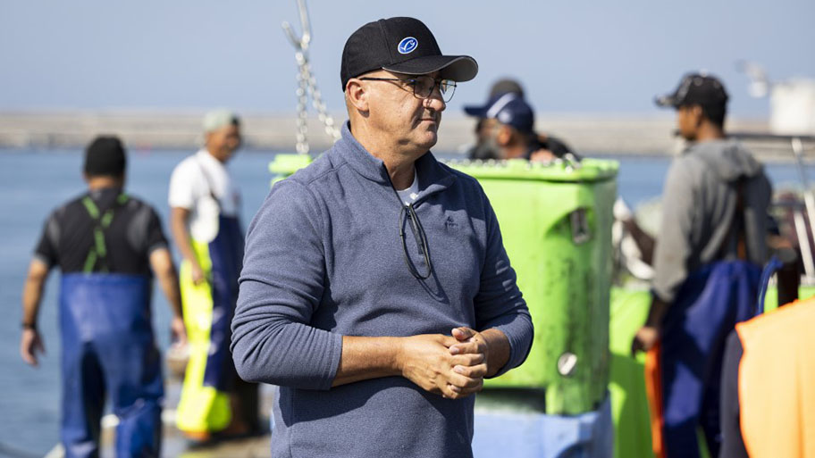 Francisco Santos, captain of the Iberian sardine vessel Vitória Coentrão on port in front of other fishers, Portugal