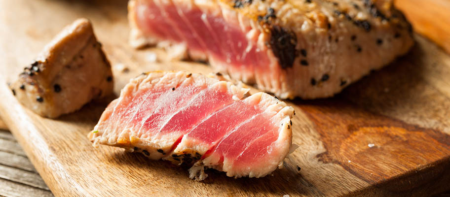 Grilled tuna steak on wooden chopping board