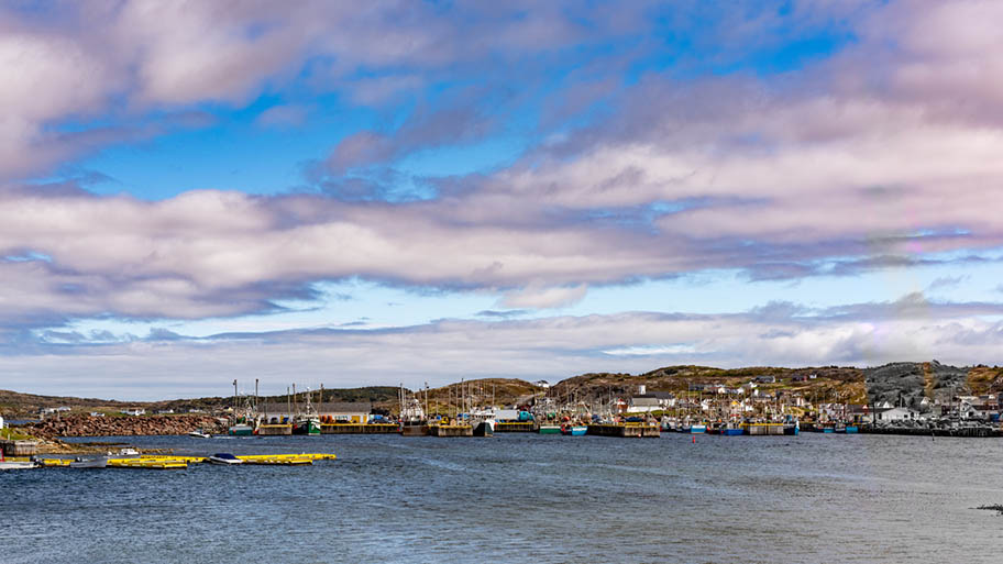 Wide shot of harbour in Newfoundland with blue and cloudy sky