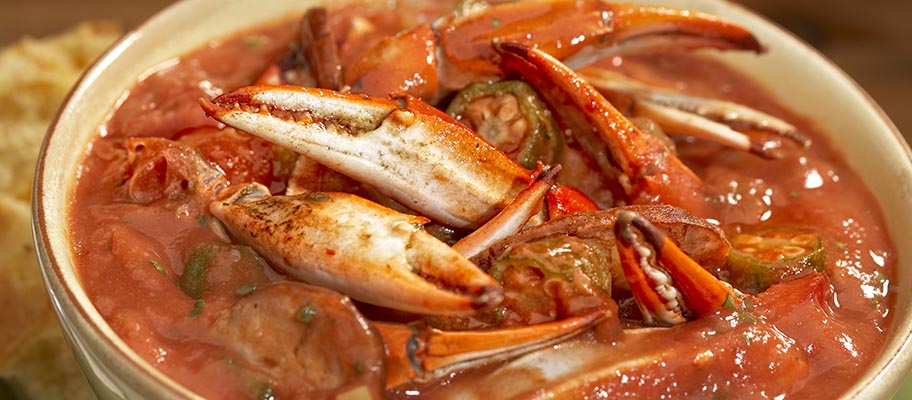 Bowl containing crab claws and sauce