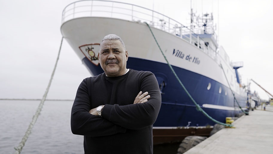 Hake fisher, Wayne Forbes, standing in front of large vessel, Namibia
