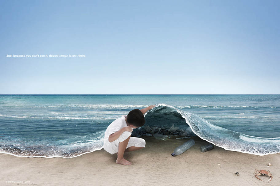 Plastic under waves on a beach - boy on beach 'lifting up' the ocean to discover plastic.