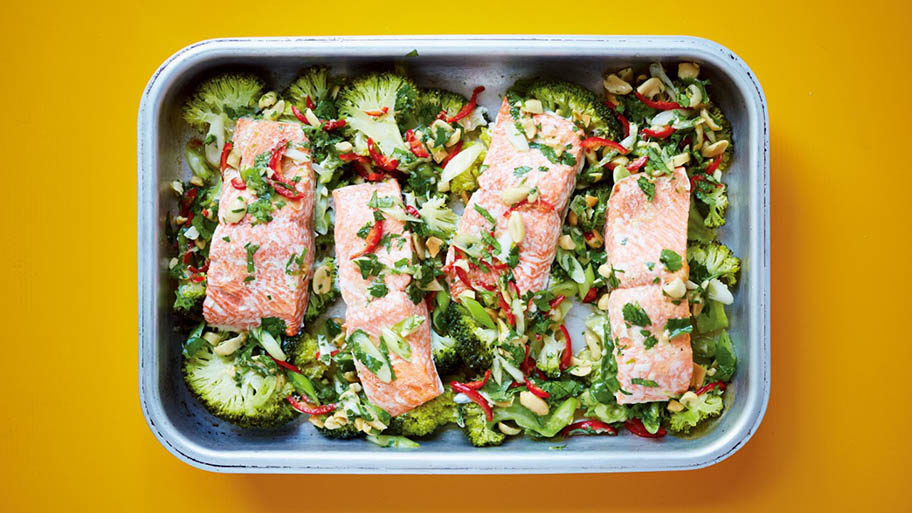 Salmon and broccoli in tin dish shot from above on orange surface