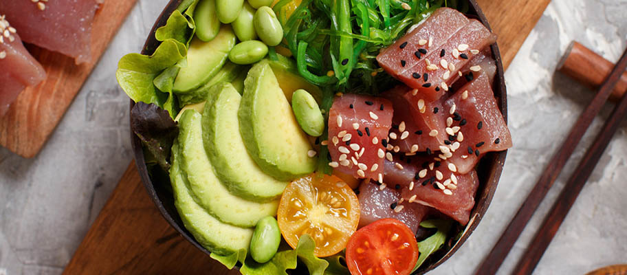 Raw tuna in bowl with avocado, tomatoes and beans, from above