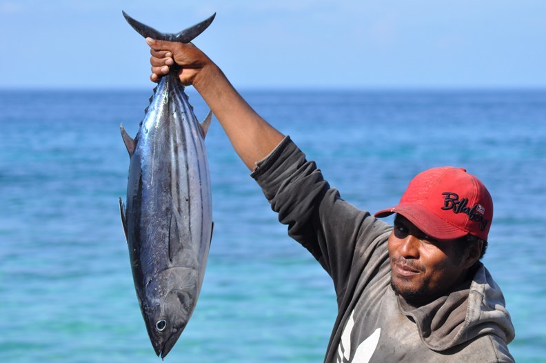 Man in red hat holding large tuna