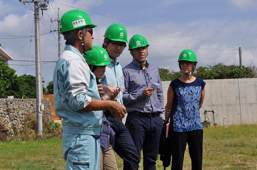 Five people outdoors in green hard hats - Euglena farm assessment