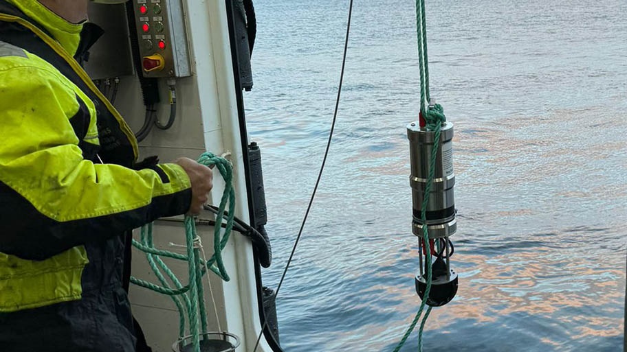 Man lowering acoustic startle device into water