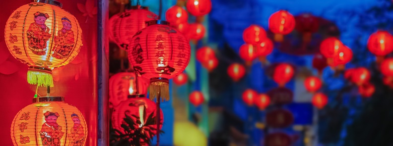 Red Chinese New Year lanterns hanging on a wall.