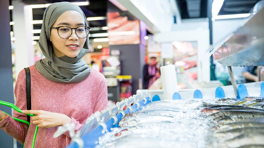 Woman wearing a hijab buying seafood