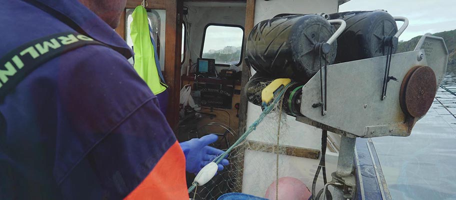 Close-up of fisherman reeling net with Fishtek Marine banana pinger