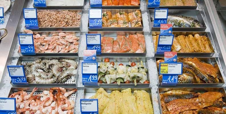 A cold food storage counter with seafood.
