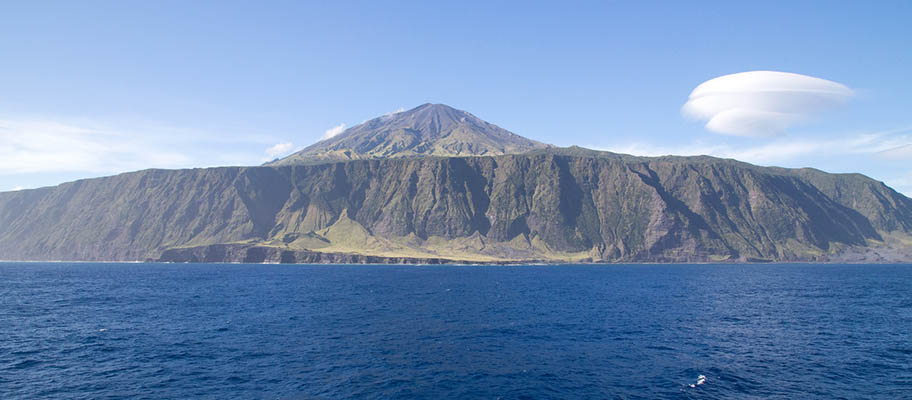 Island of Tristan da Cunha with clouds above and sea in foreground