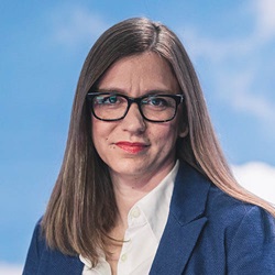 Headshot of woman wearing glasses with blue sky background (Michaela Reischl)