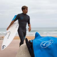 Aritz Aranburu on beach holding surfboard with MSC branded jacket in foreground