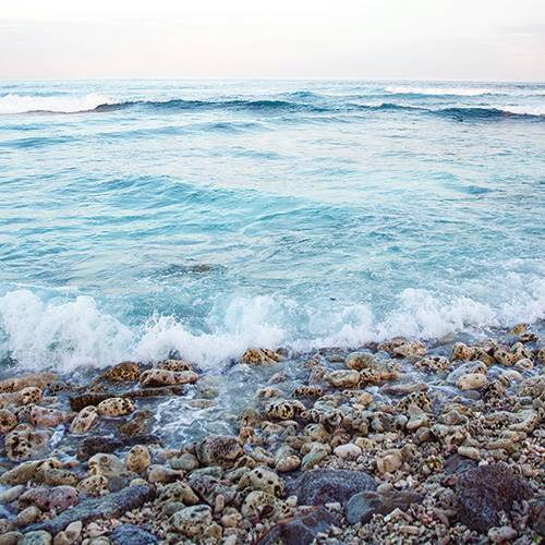Waves crashing on stony beach, Maldives