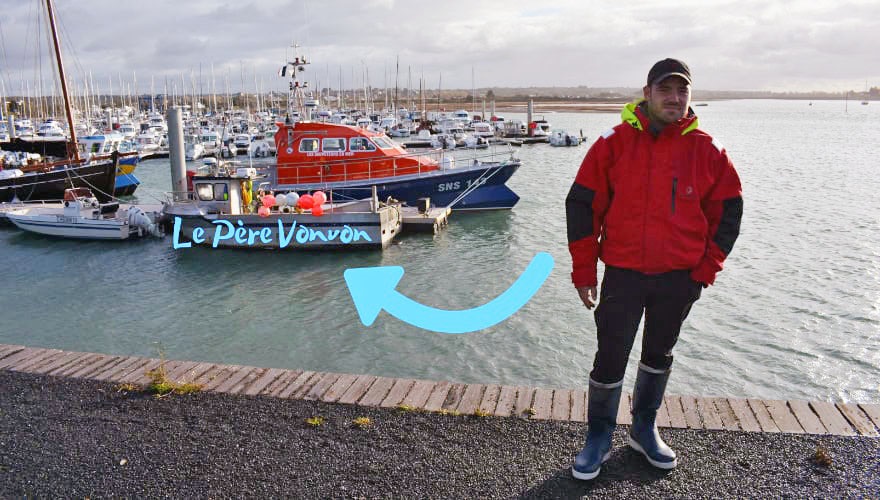 Fisherman in silhouette in front of boat with text overlay of boat name "Le Pere Vonvon"