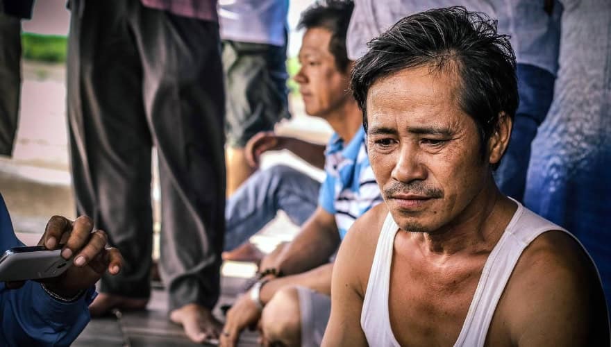 Men close up sitting on floor, Ben Tre, Vietnam