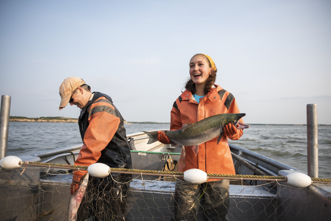 Fisher smiling with a freshly caught salmon