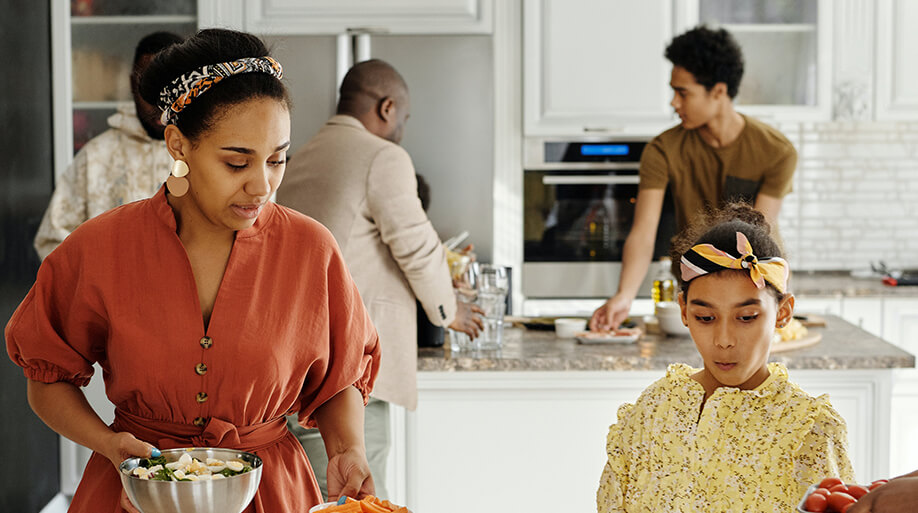 Mother and daughter setting table next to kitchen