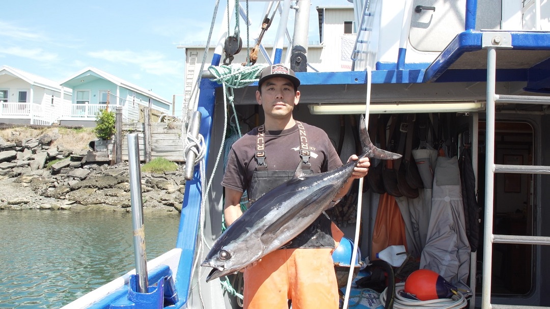 Fisherman holding a whole, frozen albacore tuna