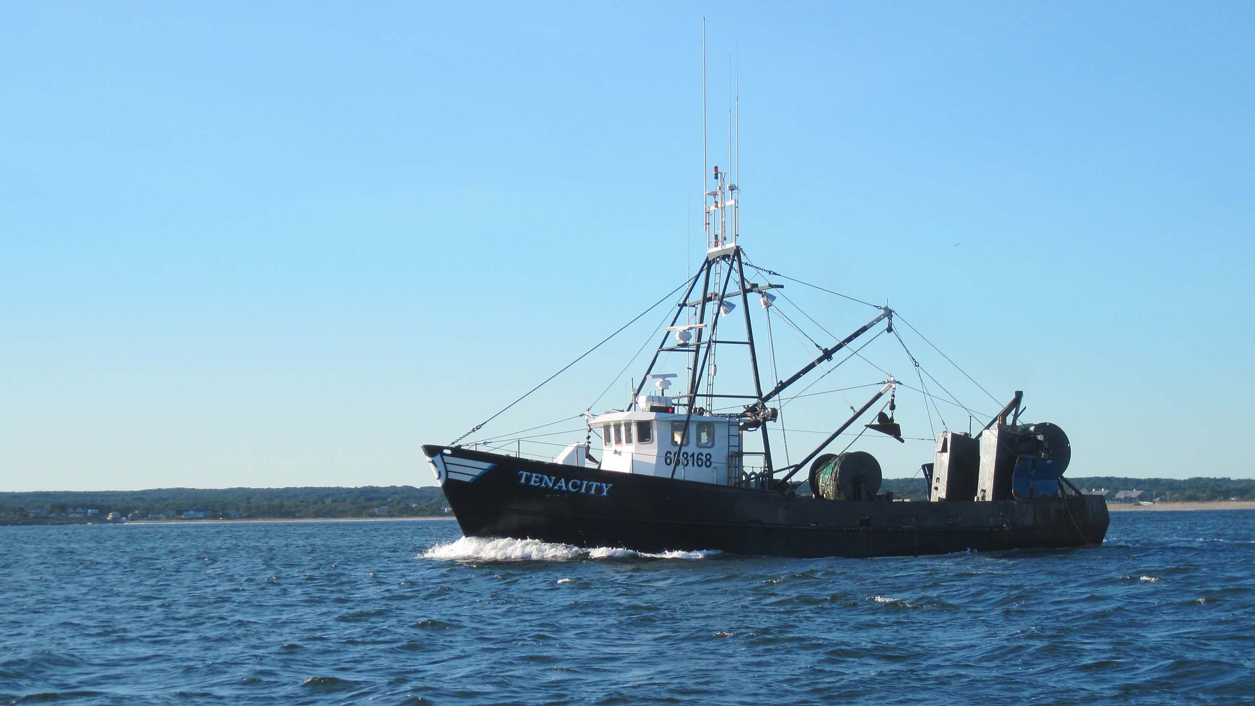 A squid boat at sea on calm waters