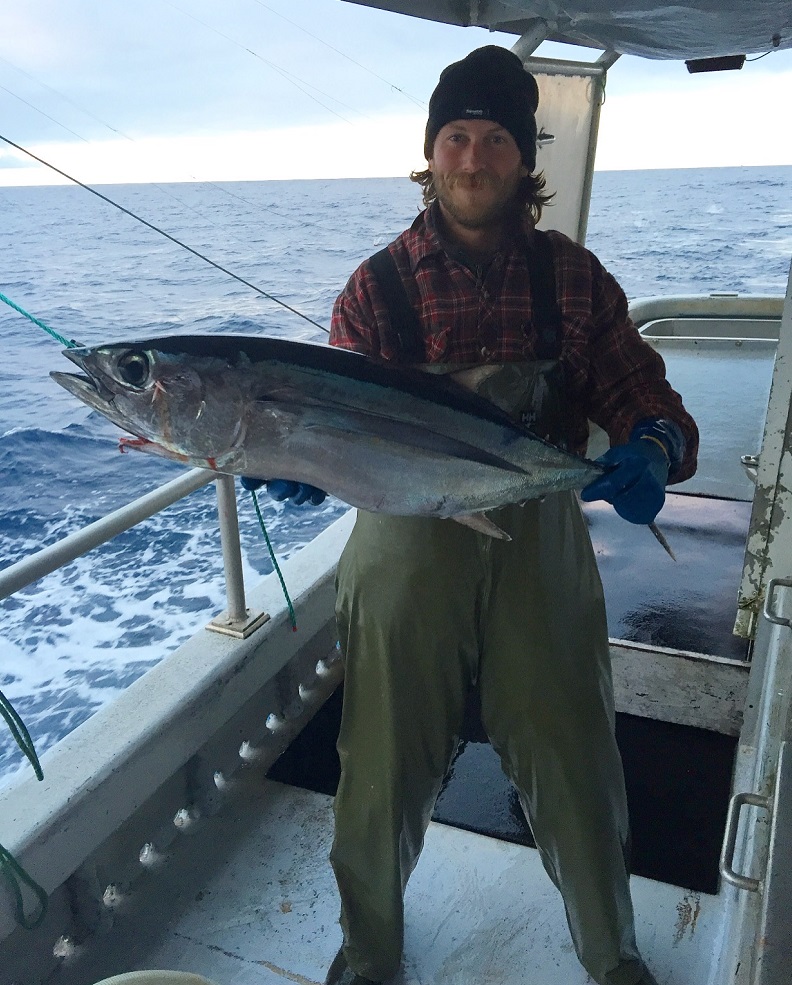 Fisher holding albacore tuna Fisher on a boat holding freshly caught albacore tuna