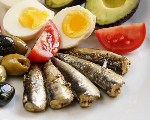 Sardines fanned out on plate along with other ingredients
