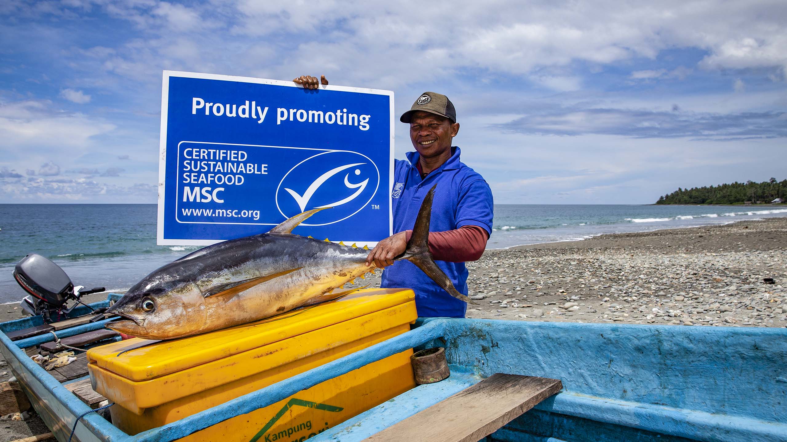 Tuna fisher holding up an MSC sign in front of a tuna he caught