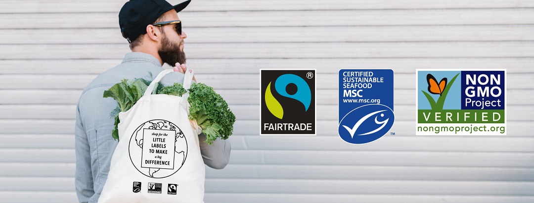 Man holding a reusable shopping bag with the MSC, Fairtrade, and Non-GMO labels