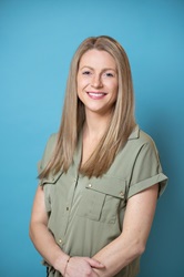 Professional headshot of Laura McDearis on a blue background