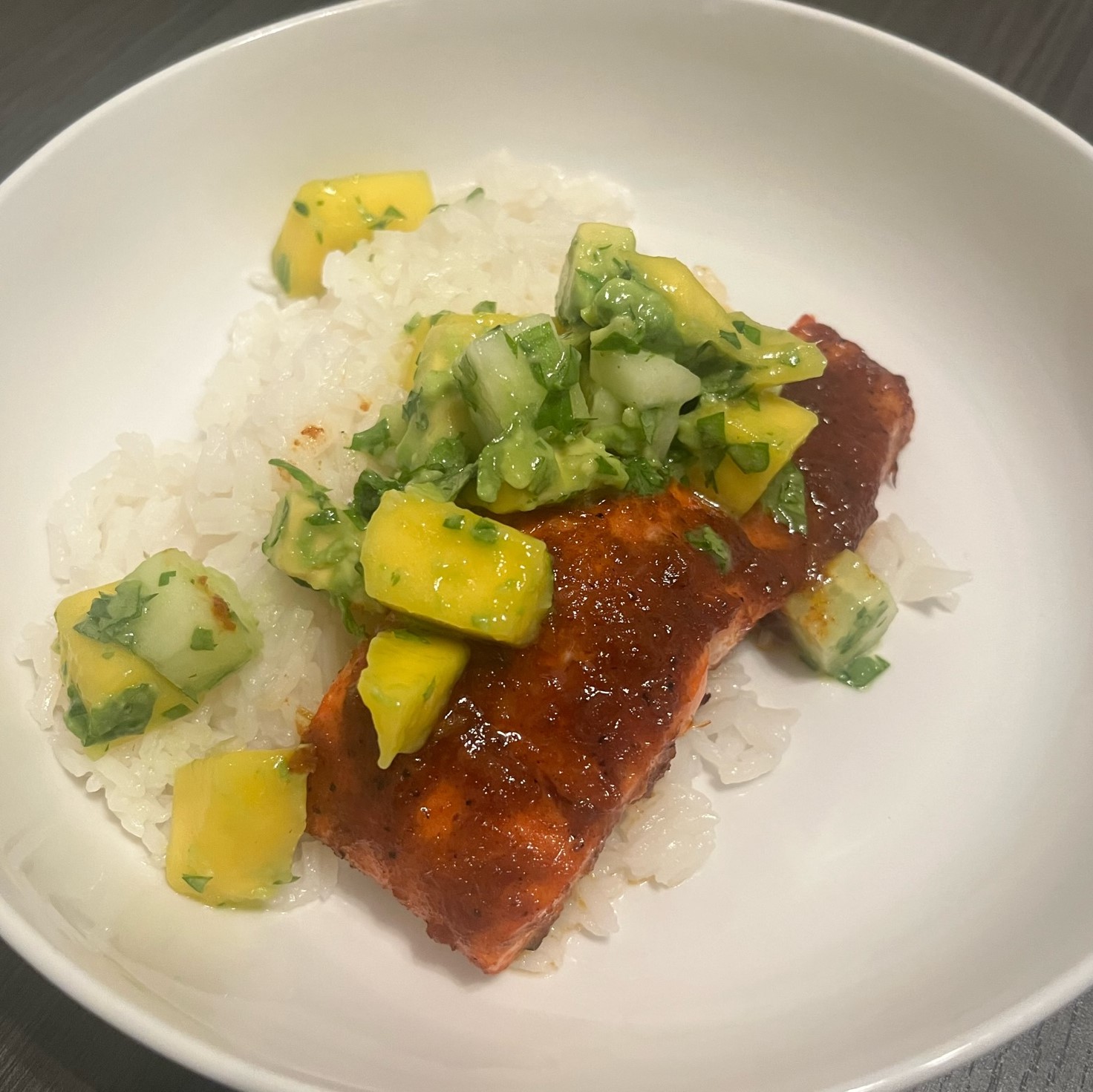 Salmon filet on rice with mango and avocado salsa