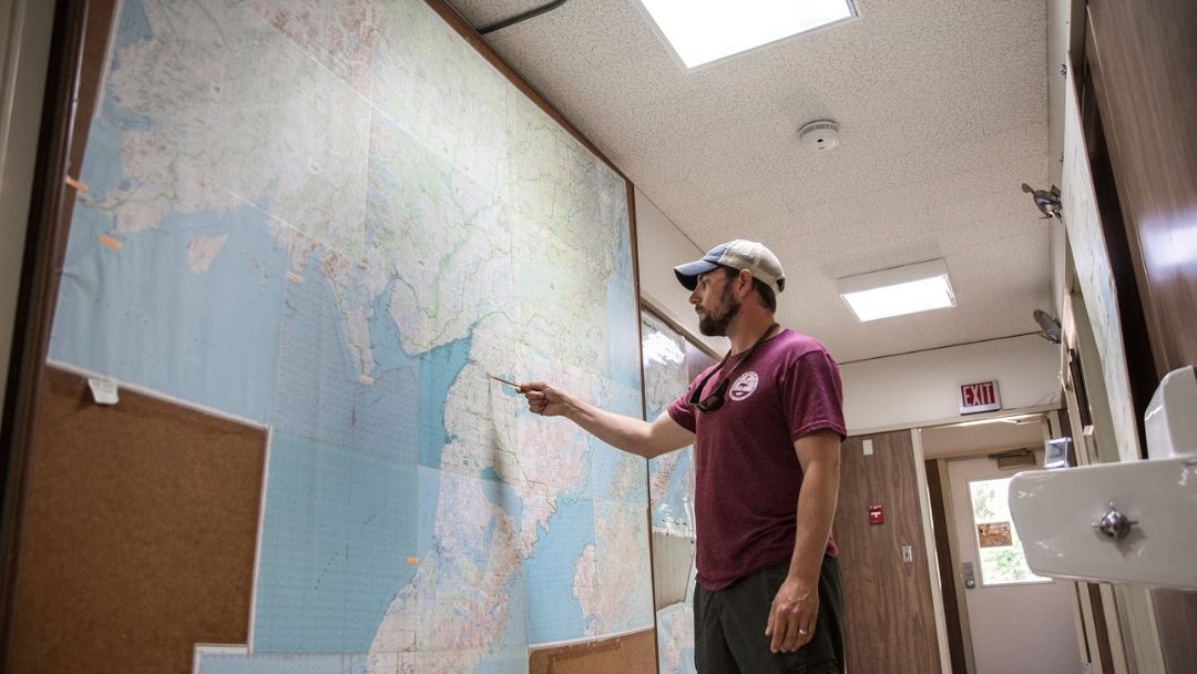 Salmon manager reviewing salmon locations on a map in an office