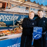 medewerkers van Vismakelaar Poseidon poseren voor de viskraam