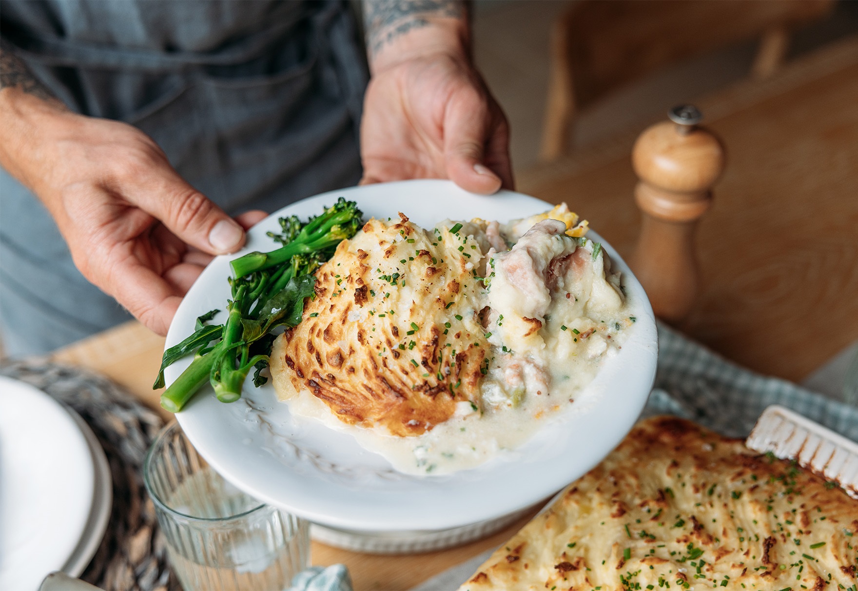 Fish pie with cheddar mash on plate in hands