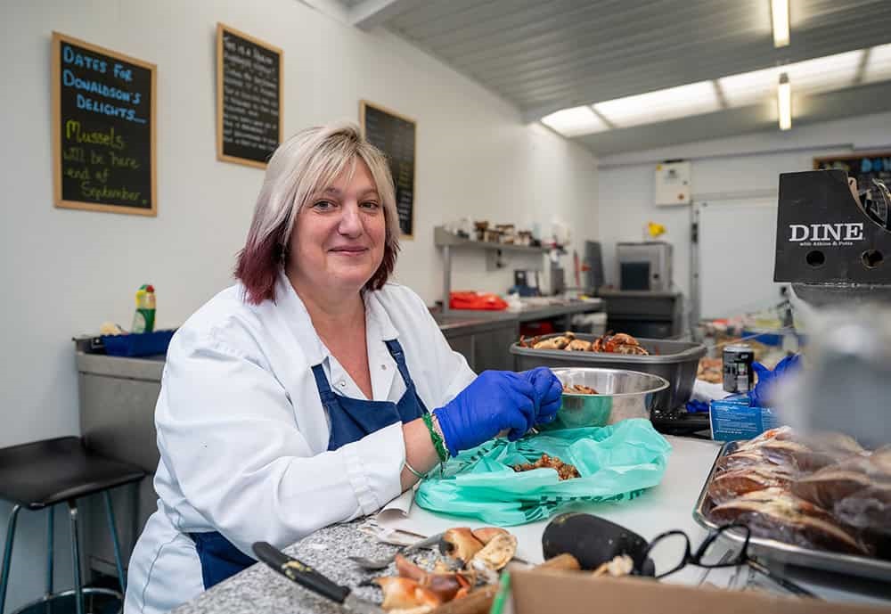 Fishmonger Sarah Marsh peeling the brown shrimp