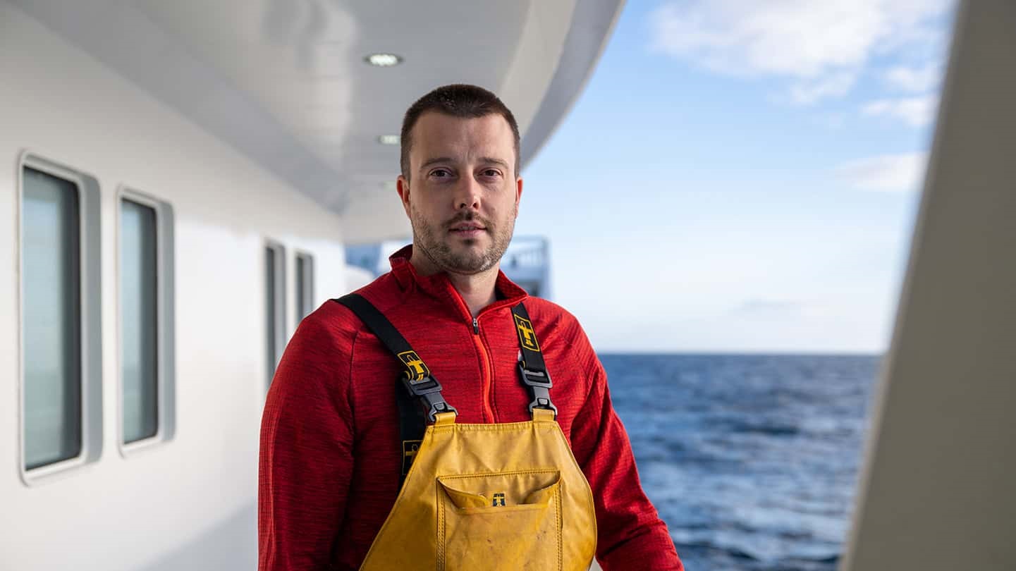 Portrait of Adam Wiseman standing on deck looking at the camera