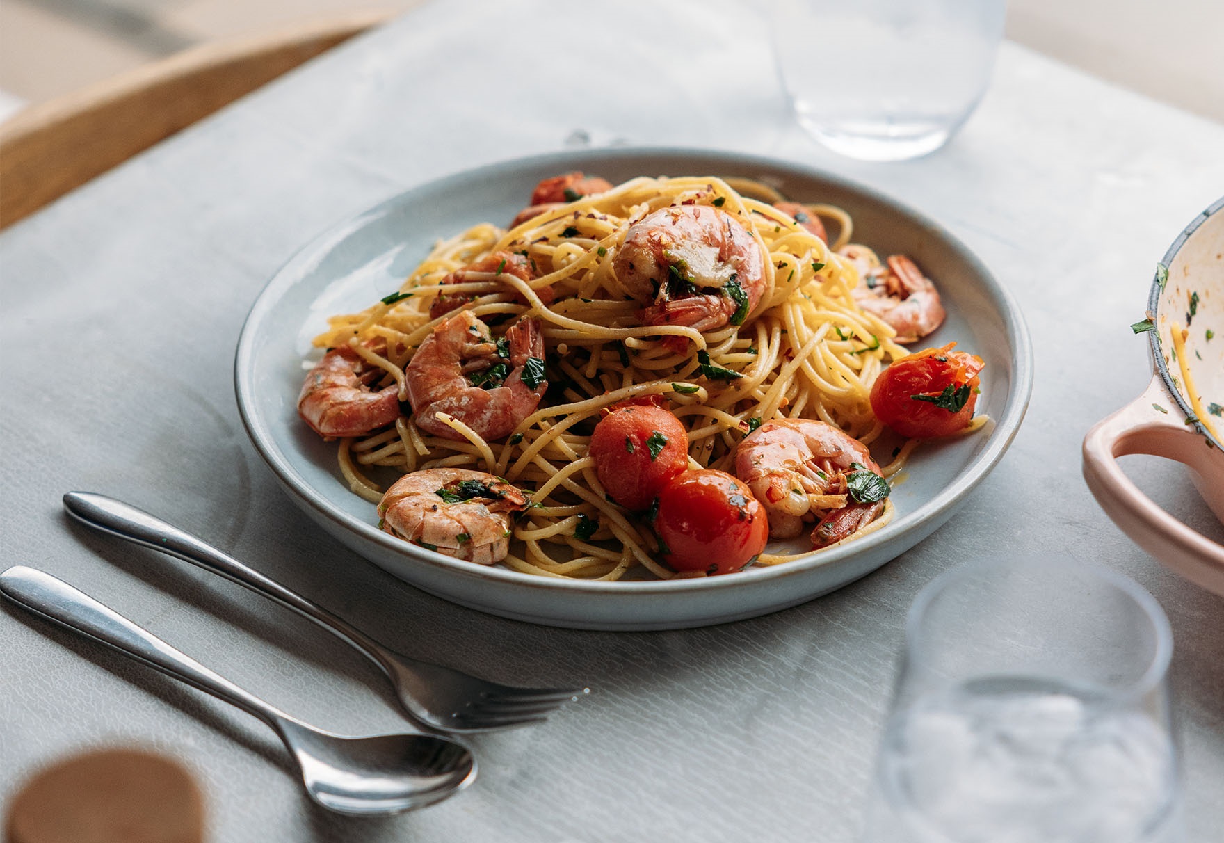 Prawn spaghetti with cherry tomatoes and utensil on the table
